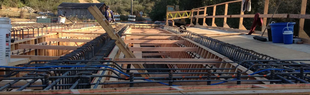 Reinforcing steel tied and formwork set for a deck pour, with a crew member working at the far end